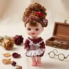 Muñeca de juguete pequeña con vestido bordó y broches en el pelo
