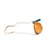 Cartera bandolera color mostaza con correa de cadena sobre piso de madera