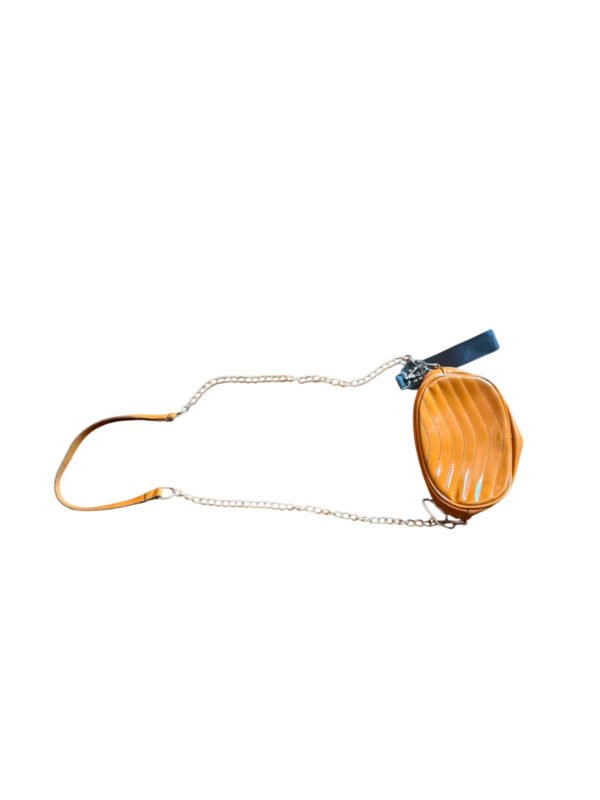 Cartera bandolera color mostaza con correa de cadena sobre piso de madera