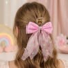Broche para el pelo con moño rosa de organza con mariposas y perlas